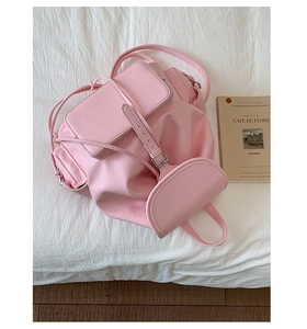 Pink vintage backpack with buckle flap and side zipper pocket on white fabric