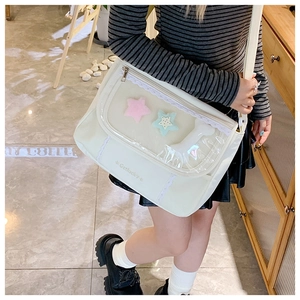 Detail of white canvas ita bag with transparent PVC window and lace trimming on cross-body strap