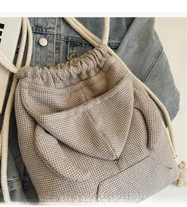 Detailed view of beige waffle texture backpack with hoodie design and thick white rope straps