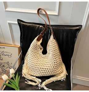 Detail of crochet boho tote bag featuring hollow knit patterns and long decorative fringes