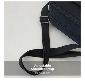 Detail of adjustable nylon shoulder strap with metal buckle on black crossbody bag