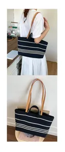 Detail of striped canvas tote bag with brown leather handles for daily commuting