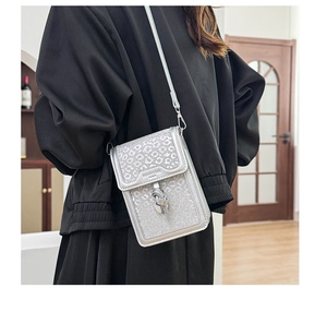 Detail showing the silver leopard print glitter texture and buckle of the crossbody phone bag