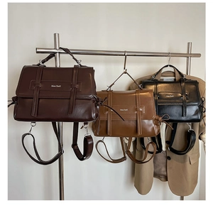 Vintage soft leather tote bags in dark brown, caramel and black hanging on a rack