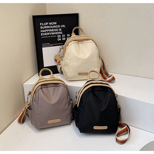 Detail of trendy nylon mini backpacks in three colors with striped woven shoulder straps
