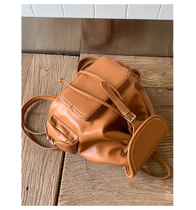 Brown soft leather backpack featuring a drawstring closure and vintage buckle flap design