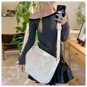 Close-up of a white fashion ita bag featuring lace edges and clear window for plushies