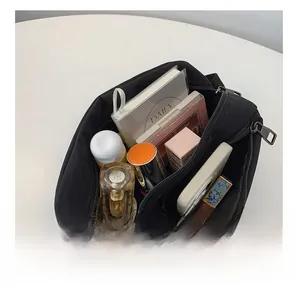 Internal compartments of black nylon crossbody bag showing spacious storage for essentials