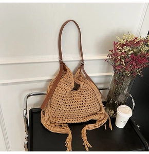 Detail of hand-woven crochet mesh tote with flowing tassels and brown leather shoulder strap