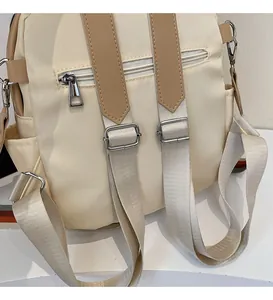 Detail view of adjustable beige nylon backpack straps and hidden anti-theft back pocket