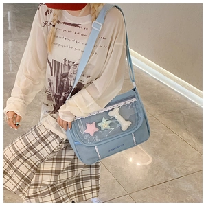 Detail of blue canvas messenger bag with clear PVC star pocket and lace trim accents