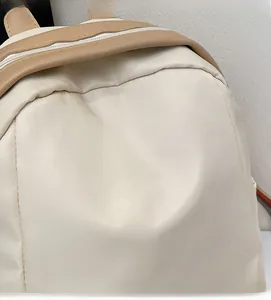 Detailed close-up of lightweight beige nylon fabric and premium brown leather zipper trim