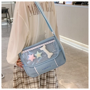 Detail of light blue crossbody ita bag with clear PVC window and star charms