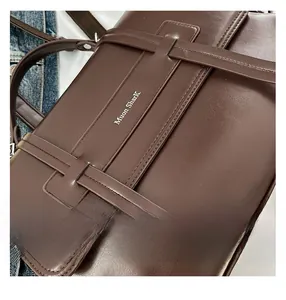Macro detail of dark brown soft leather texture and fine stitching on shoulder bag