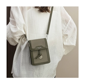 Detail of a dark green vintage crossbody phone bag with a leather-knot metal buckle