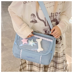 Detail of light blue ita bag with transparent window, lace trim and plush charms