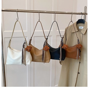 Détail de quatre sacs sous les bras de couleur unie avec ours en peluche et foulards