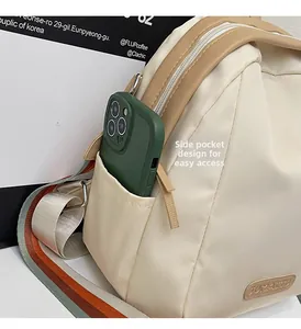Detail of cream nylon bag side pocket for quick access with colorful striped strap