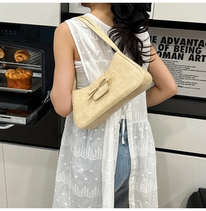 Close-up of a beige textured leather shoulder bag featuring a stylish bow decoration