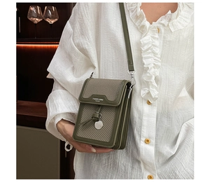 Detail of dark green crossbody phone bag featuring a woven fabric and leather texture design