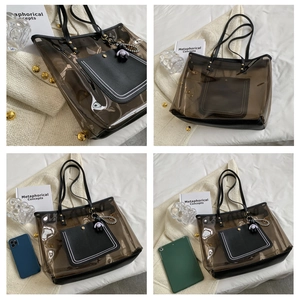 Détail du sac cabas transparent marron avec bordure noire et breloque astronaute