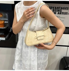 Detail view of the creamy yellow underarm bag with rock texture and bow decoration