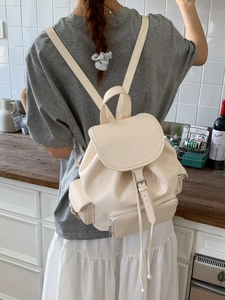 Minimalist beige PU leather backpack with buckle flap and multiple pockets on a model