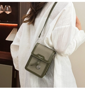 Detail of olive green woven mini square bag with silver pendant and leather shoulder strap