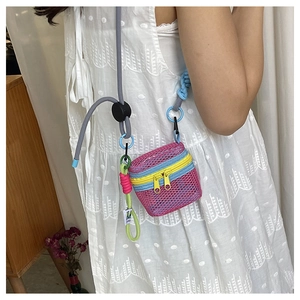 Detail of a pink mesh mini crossbody bag with colorful zippers and woven rope strap