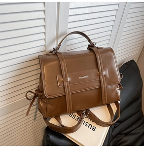 Close-up of vintage brown leather backpack featuring dual straps and branded front flap