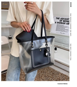 Détail du grand sac cabas en PVC dépoli avec poches en cuir noir et bijou de sac