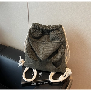 Detail of olive green waffle knit bucket bag featuring a drawstring and hood pocket