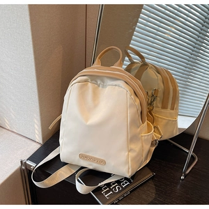 Detail view of cream mini backpack showing nylon texture and JUMAITU brand name tag
