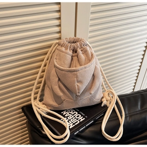 Close-up of waffle-knit fabric on a hoodie-shaped drawstring bucket bag with pockets