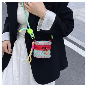 Close-up of a colorful mini mesh crossbody bag with a red zipper and green strap details