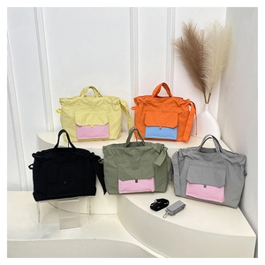 Détail des sacs cabas en nylon en cinq couleurs avec des poches avant contrastées