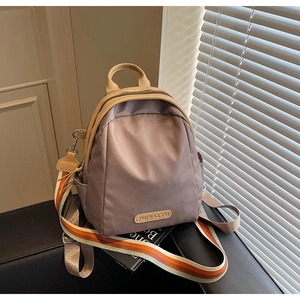 Detail of mauve nylon mini backpack with leather trim and colorful striped shoulder strap