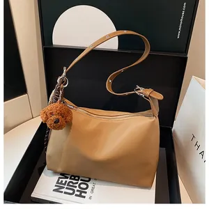 Détail du sac sous le bras en nylon marron clair avec breloque chien et boucle argent