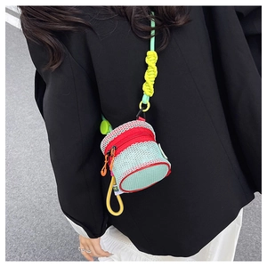 Detail of mint green mesh cylinder bag with orange zipper and thick braided rope strap