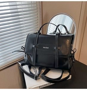 Detail view of the black leather Muon Shark tote bag with adjustable strap and branding