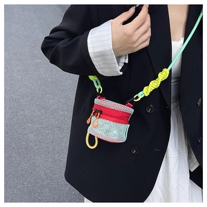 Detail of colorful mini mesh crossbody bag with neon knots and textured fabric