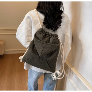 Detail of hoodie-style olive tweed backpack with drawstring and decorative hoodie back
