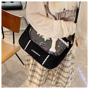Detail of black canvas messenger bag with transparent PVC pocket and white lace trim