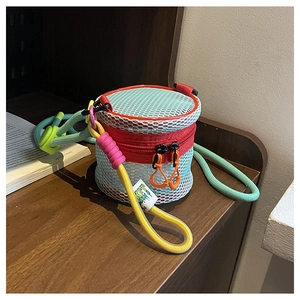 Detail of a mini mesh cylinder crossbody bag featuring vibrant color-blocking designs