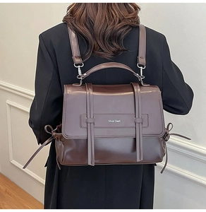 Detailed back view of a vintage dark brown leather backpack with adjustable straps