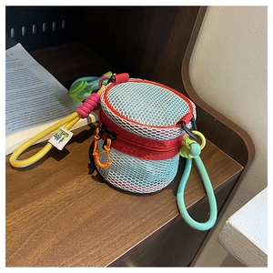 Detail of colorful hollow out mesh mini bag with vibrant zippers and woven strap