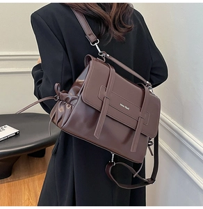 Side view of dark brown soft leather bag with silver logo and drawstring detail