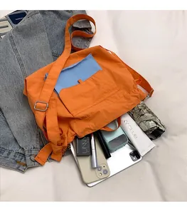 Détail du sac fourre-tout en nylon montrant un intérieur spacieux avec des objets du quotidien