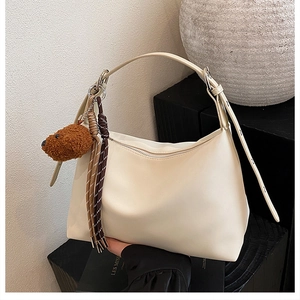Détail du sac hobo blanc crème avec charm ours brun et accent de corde tressée