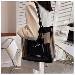 Détail du sac cabas transparent en PVC avec bordure en cuir noir et breloque chat